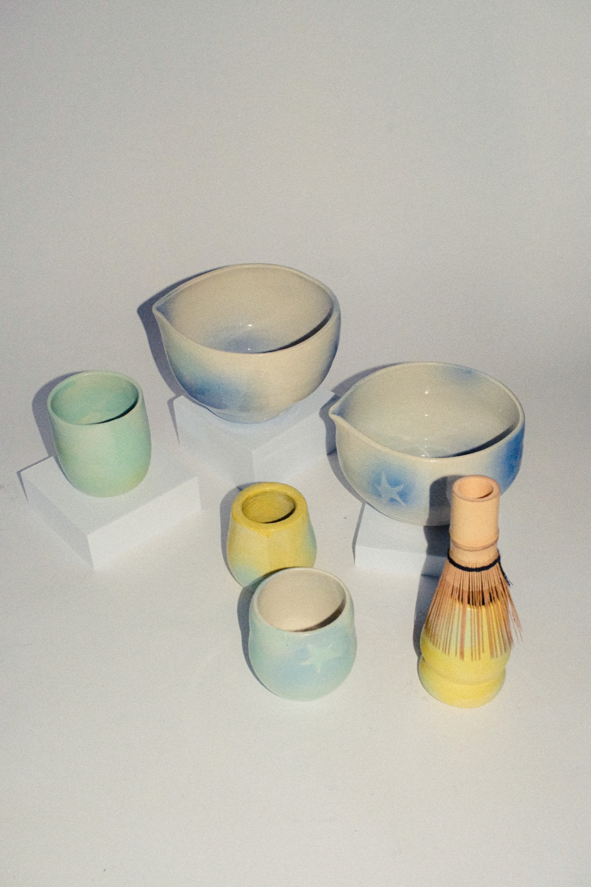 Styled group of cups, bowls, and a bamboo whisk
